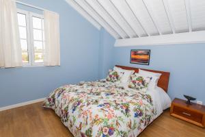 a blue bedroom with a bed and a window at Whale Song in Feteiras +34 photos
