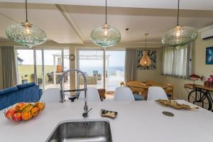 a kitchen with a sink and some glass pendant lights at Whale Song in Feteiras
