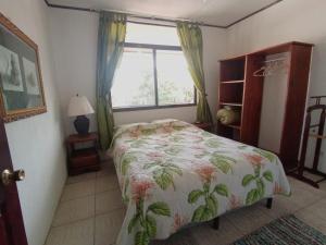 a bedroom with a bed and a window at Nirvana Apartament Hostal in Alajuela