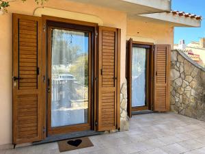 a house with wooden doors and a balcony at Crock House in Funtana Meiga