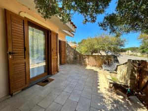 a house with a patio with a door and a window at Crock House in Funtana Meiga