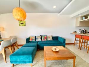 a living room with a blue couch and a table at Tropical Luxury 2Bdr condo - Pool view - At the Beach in Tamarindo