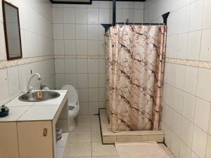 a bathroom with a shower curtain and a sink at Los Balcones Over The Sea in Bocas Town