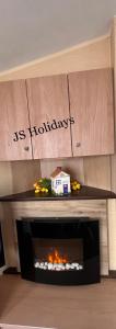 a fireplace in a living room with a box on top at JS Holidays The Westmorland Lagganhouse in Ballantrae