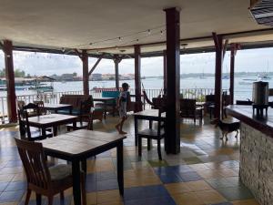 a boy and a dog walking in a restaurant with tables at Los Balcones Over The Sea in Bocas Town