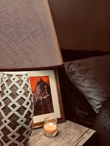 una candela su un tavolo accanto a un'immagine e a una lampada di Montana Inn a Wadi Musa