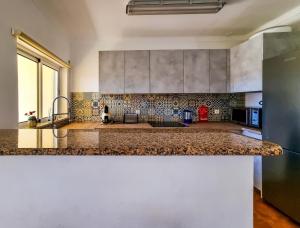 uma cozinha com um balcão de mármore num quarto em FLH Carvoeiro Beach Place with Terrace em Carvoeiro