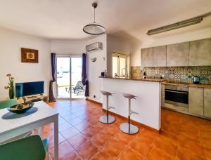 uma cozinha com um balcão e bancos num quarto em FLH Carvoeiro Beach Place with Terrace em Carvoeiro