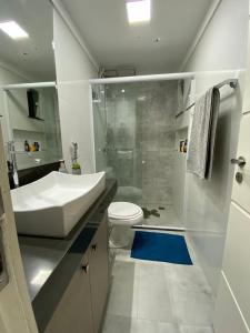 a bathroom with a sink and a toilet and a shower at Cobertura Blue Beach House in Olivença