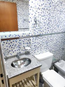 La salle de bains est pourvue d'un lavabo et de toilettes. dans l'établissement Cabaña Los Lúpulos, à El Bolsón