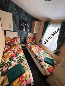BallantraeにあるJS Holidays The Westmorland Lagganhouseのベッド2台と窓が備わる小さな客室です。