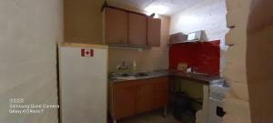 eine Küche mit einem weißen Kühlschrank und roten Schränken in der Unterkunft Finca ELSA in San Agustín de Valle Fértil + 16 Fotos