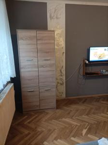 a bedroom with a dresser with a television on it at Csilla Apartman in Balogunyom