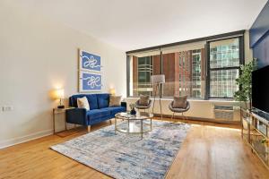 uma sala de estar com um sofá azul e uma televisão em Charming 1BR Unit Great Location - Chestnut 19H em Chicago