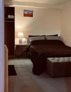 una camera da letto con un letto e un pouf di Montana Inn a Wadi Musa