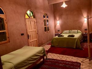 A bed or beds in a room at Riad Imuhar