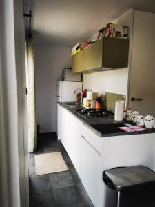 a small kitchen with a stove and white cabinets at Mobil home neuf camping l ile dor plage st raphael avec piscine in Saint-Raphaël
