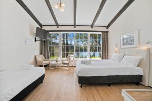 2 camas en una habitación con ventana en The Fox and Hounds Historic Hotel en Port Arthur