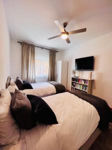 um quarto com 2 camas e uma ventoinha de tecto em Oceanview Carvoeiro Terrace Apartment em Carvoeiro