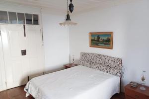um quarto com uma cama branca e uma janela em Casa da Ponte, Coja em Coimbra