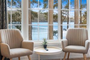 two chairs and a table in front of a window at The Fox and Hounds Historic Hotel in Port Arthur