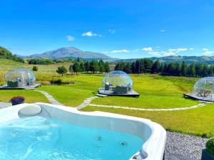 a hot tub in a field with two domes at Mingarry Park in Acharacle
