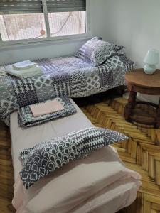 a room with two beds with pillows and a table at Recoleta Time in Buenos Aires