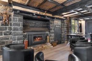 a living room with a fireplace and leather chairs at The Fox and Hounds Historic Hotel in Port Arthur