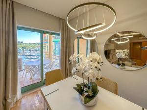 Luxury 1 Bedroom Apartment, Marina de Albufeira3 في ألبوفيرا: غرفة طعام مع طاولة مع إناء من الزهور