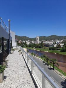 a walkway next to a river next to a building at Golden Ross Resort & Spa in Villa Carlos Paz