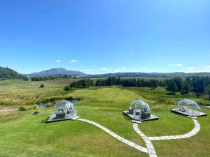 três observatórios sentados no topo de um campo verde em Mingarry Park em Acharacle