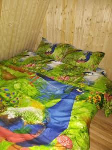 - un lit avec une couette colorée dans l'établissement Căsuțele din Zăbran, 