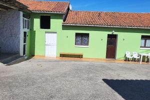 a green house with chairs and a bench in front of it at Casa Verde. in Villaviciosa