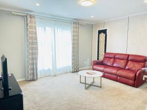 un soggiorno con divano rosso e tavolo di 99e 5-bedrooms luxury house a Hamilton