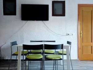 a table with chairs and a television on a wall at Lola Apartment Encorts in Valencia