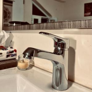 un lavandino in bagno con rubinetto cromato e candela di Montana Inn a Wadi Musa