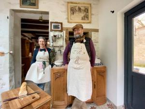 un hombre y una mujer de pie en una cocina en Rue de la Tour du Pin, en Fontaine-Française