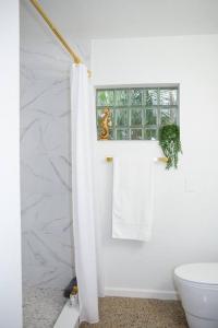 ein weißes Bad mit einem WC und einem Fenster in der Unterkunft Luxury Home Steps to Madeira Beach in St Pete Beach