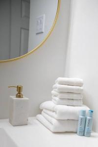 einen Stapel Handtücher auf der Badezimmertheke mit Spiegel in der Unterkunft Luxury Home Steps to Madeira Beach in St Pete Beach