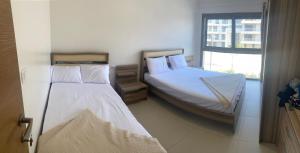 - 2 lits dans une petite chambre avec fenêtre dans l'établissement MARASSI Marina west ll 1BR 3BD near of SOL beach, à El Alamein