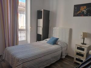 バレンシアにあるLola Apartment Encortsのベッドルーム1室(青い枕付きのベッド1台付)
