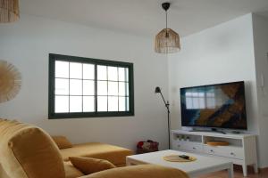 a living room with a couch and a flat screen tv at Casa Notas de Color Y Sal in Agaete