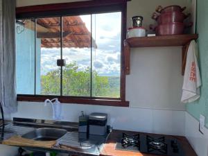 a kitchen with a sink and a window with a view at ninho da arara in Sao Jorge