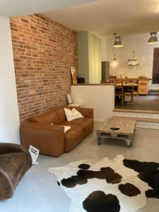 a living room with a brown couch and a brick wall at SUITE-DREAMS LOFT - Innenstadt in Hannover