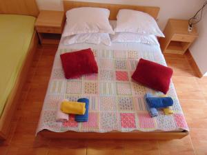 a bed with four pillows and a quilt on it at Studios Ravlić Marija in Makarska