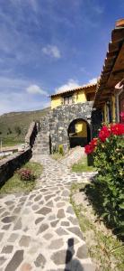 una persona caminando por un camino de piedra junto a un edificio en Lodge Mirador San Antonio- Colca, en Coporaque