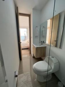 ein Badezimmer mit einem WC, einem Waschbecken und einem Spiegel in der Unterkunft Apartamento Moderno y lujoso con vista al mar Piso 1903 - cerca a ciudad amurallada in Cartagena de Indias
