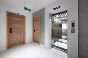 an empty hallway with two wooden doors in a building at Bi Eco Suites Hanoi in Hanoi