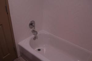 bañera blanca con grifo en el baño en Americas Best Value Inn Port Aransas, en Port Aransas