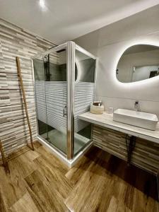 ein Bad mit einer Glasdusche und einem Waschbecken in der Unterkunft Ti Kaz Coco JUNGLE Jacuzzi & vue mer in Bouillante